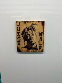 a piece of wood with a picture of a rapper on it