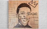 a wooden plaque with the image of king chris brown